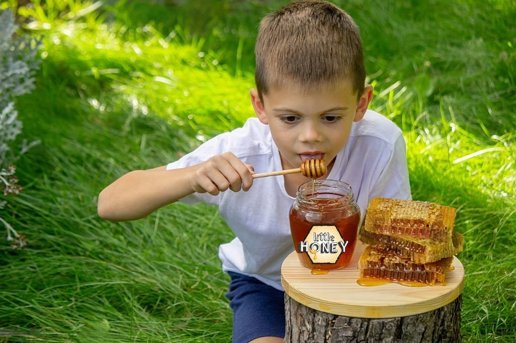 A jar of natural honey with a wooden dipper beside a glass of milk, fruits, and toast, symbolizing the health benefits of honey for kids’ growth, energy, and immunity.