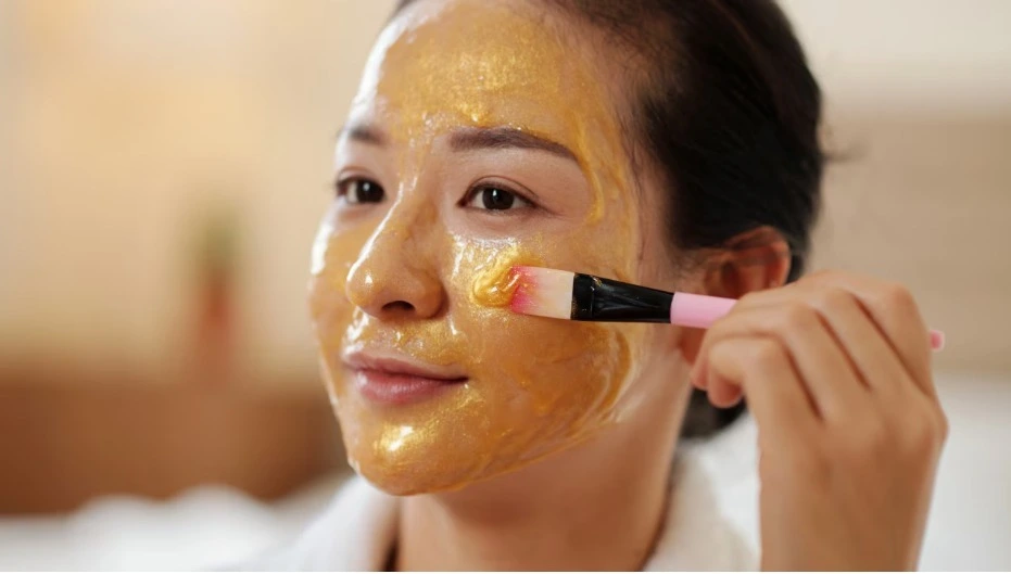 Woman applying a honey face mask for skin whitening, using honey for skin whitening to achieve a natural glow.