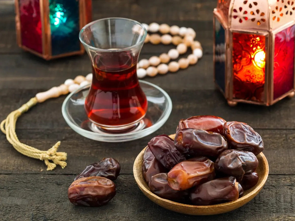 Plate of dates with tea and lanterns, eating dates during Ramadan fast-breaking tradition at iftar