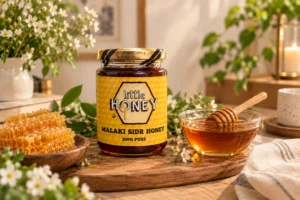 Jar of Little Honey Sidr Malaki Honey with a wooden honey dipper.